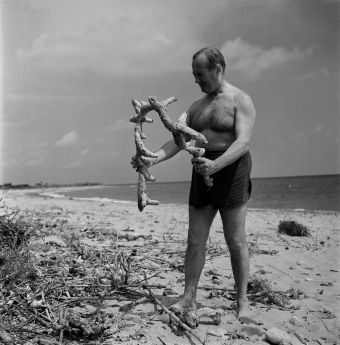 Joan Miro on the beach collecting objects for his sculptures.