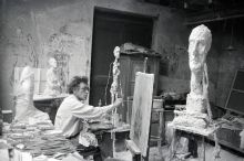 Giacometti in his Paris studio, next to him the sculpture 